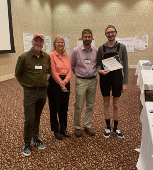 Zachary Mathe (rechts) mit den Organisatoren der Konferenz (von links nach rechts): John Peters, Wendy Shaw, Eric Wiedner.